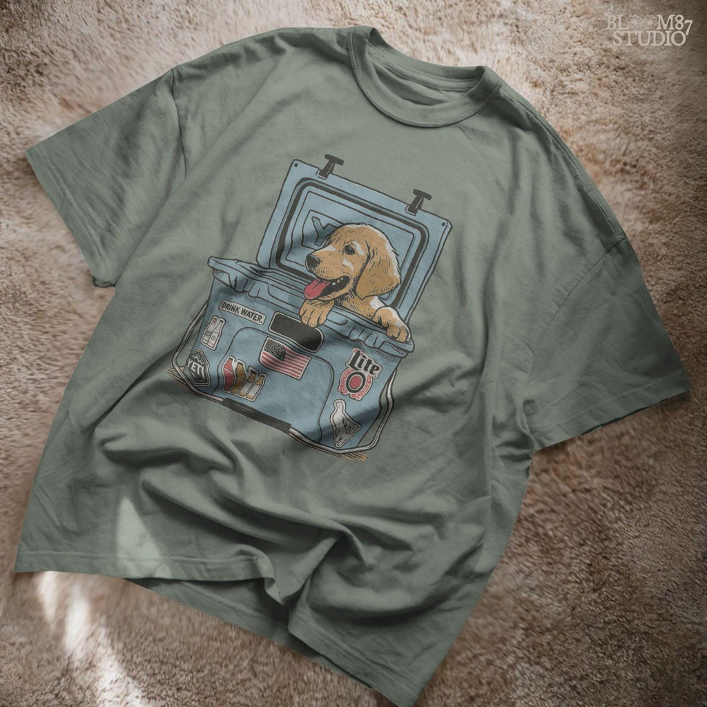 Illustration of a golden retriever puppy sitting inside a YETI cooler covered in stickers, designed for sublimation and lake life dog dad gifts.