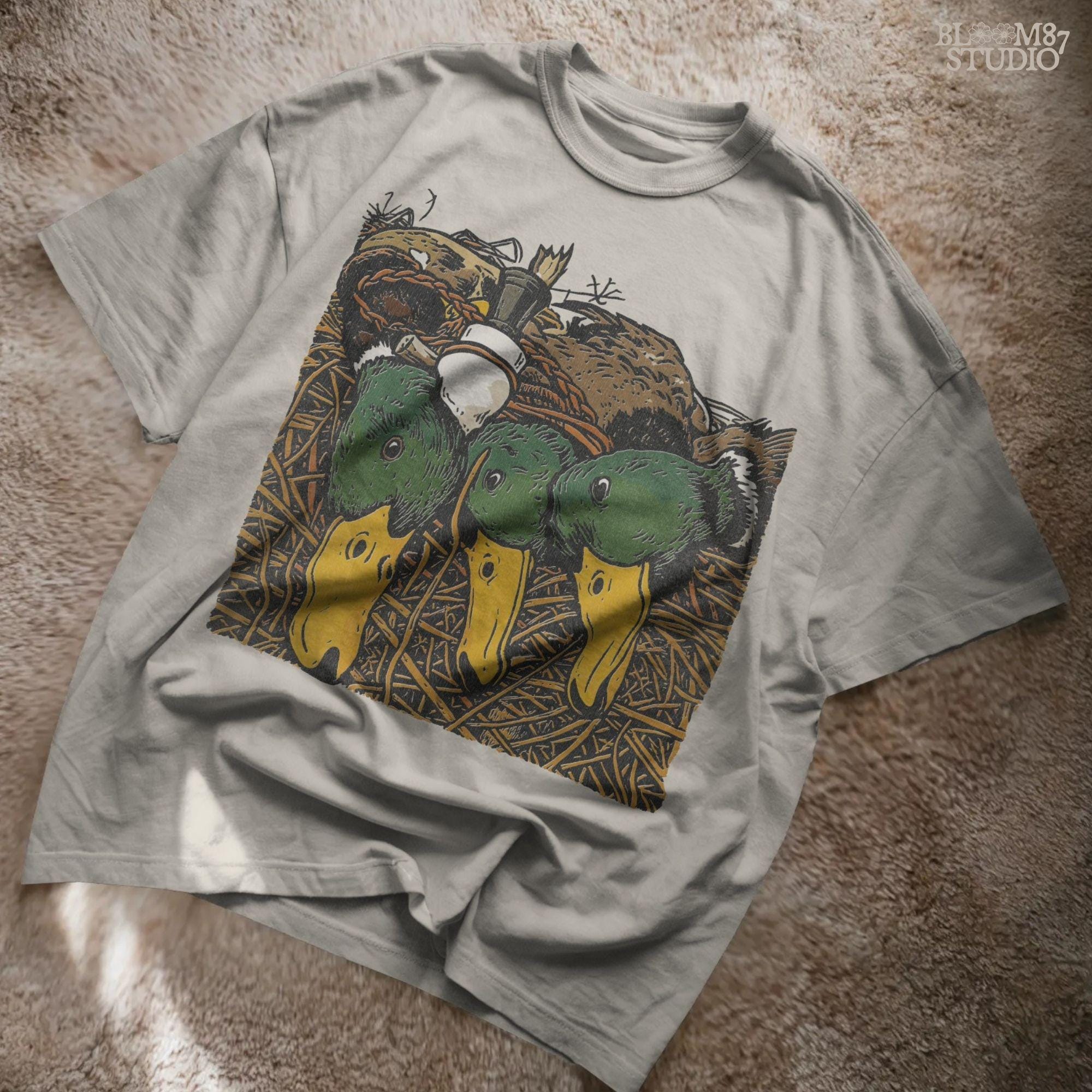 Illustration of three drake mallard ducks with green heads and yellow bills, lying in marsh grass with a duck call, hunting PNG sublimation design