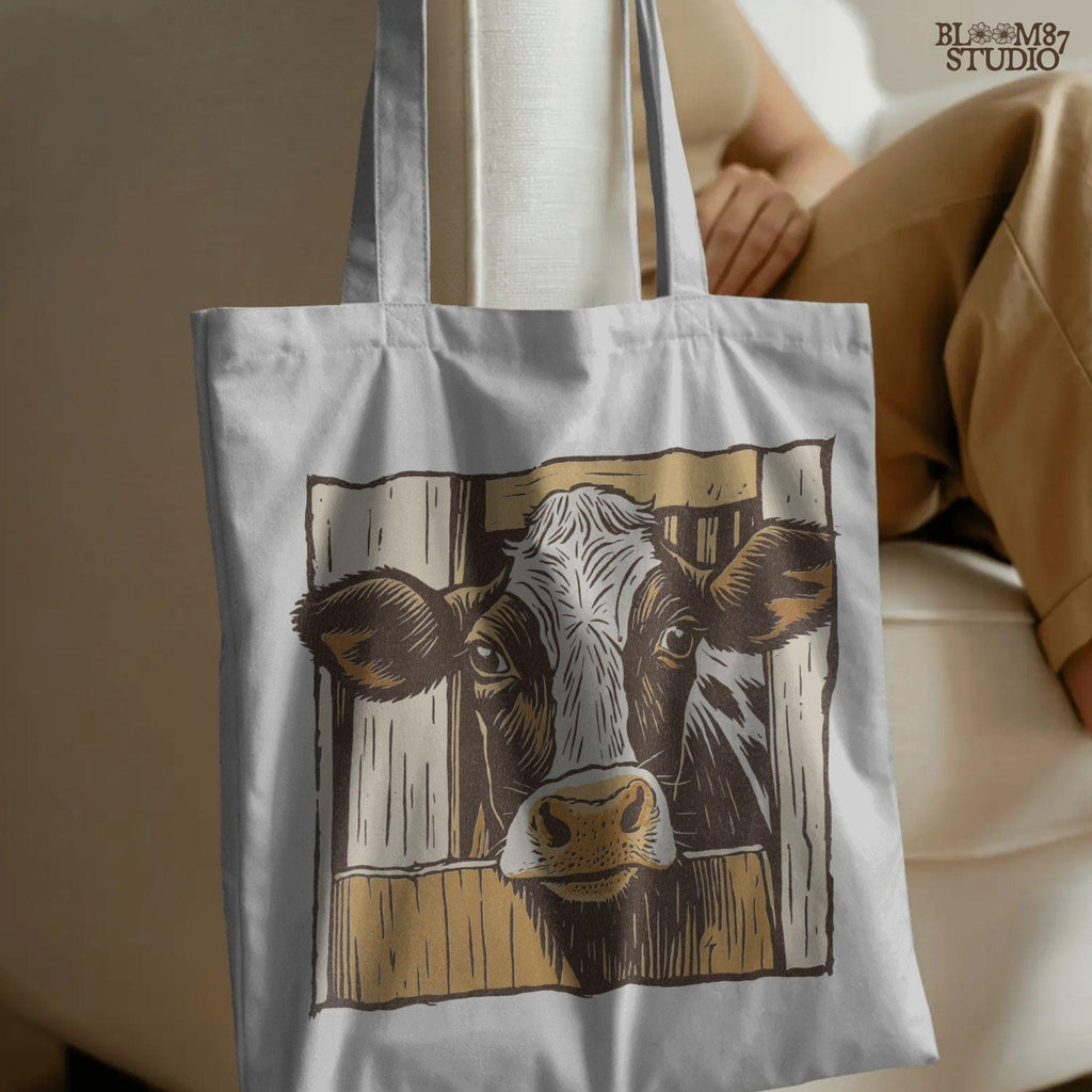 Illustration of a black-and-white dairy cow peeking through a rustic wooden barn door, farmhouse-style sublimation PNG design