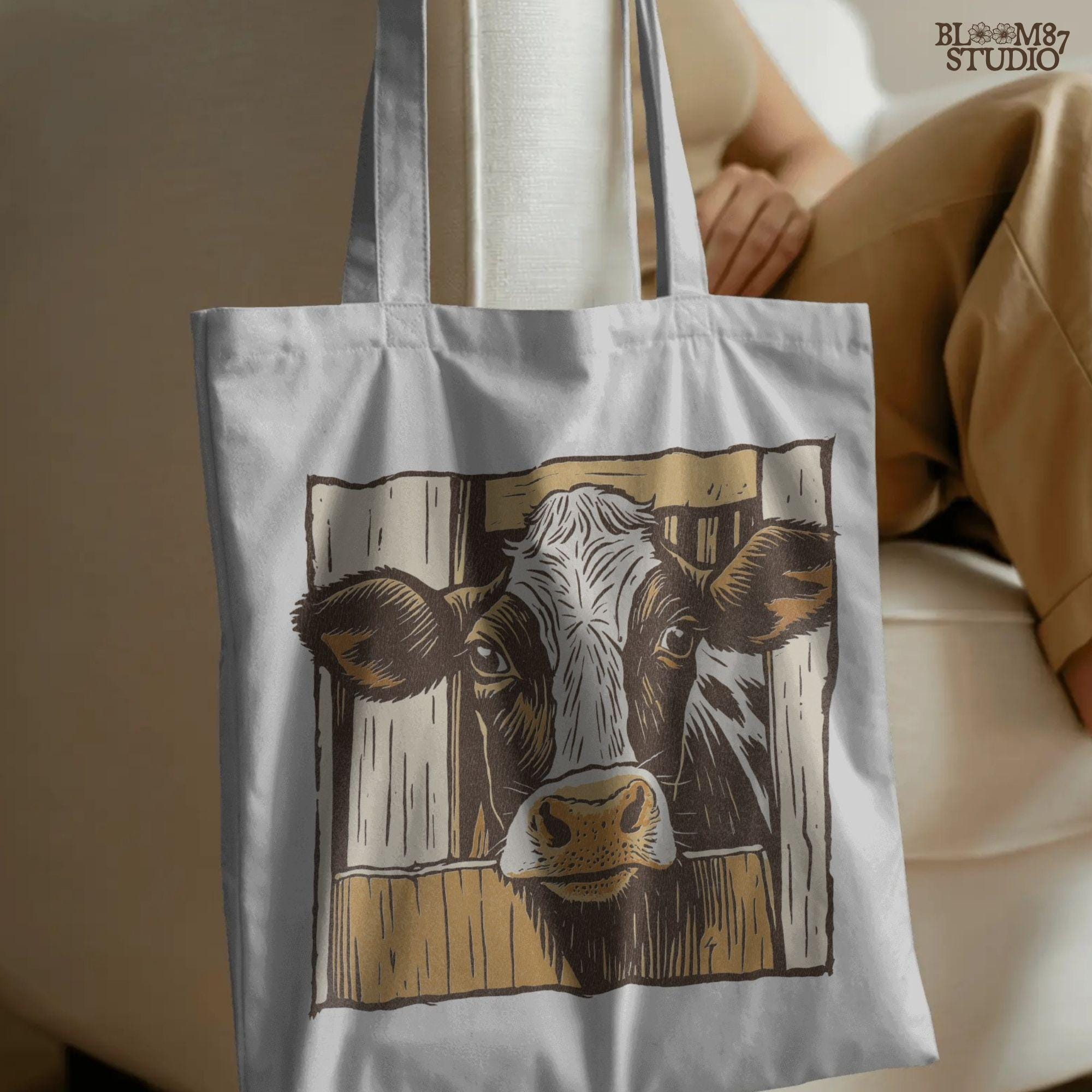 Illustration of a black-and-white dairy cow peeking through a rustic wooden barn door, farmhouse-style sublimation PNG design