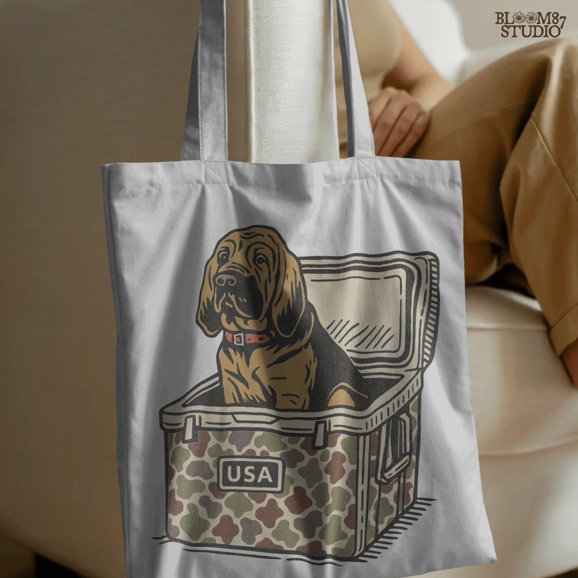 Illustration of a brown bloodhound dog sitting inside a camouflage cooler with “USA” label, hunting and outdoor-themed sublimation PNG design