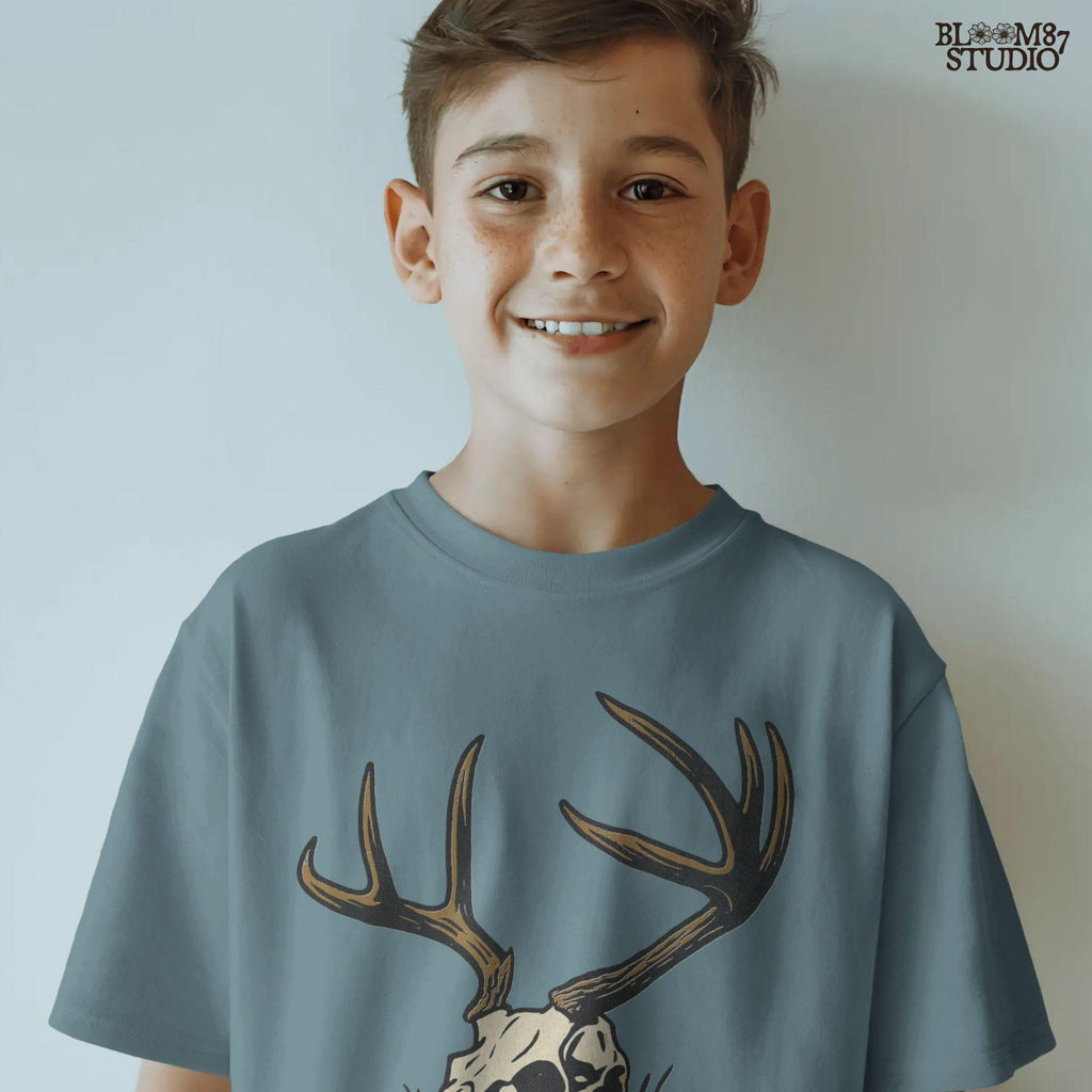 Rustic illustration of a deer skull with large antlers lying on grass, PNG design for hunting-themed and western-style sublimation crafts