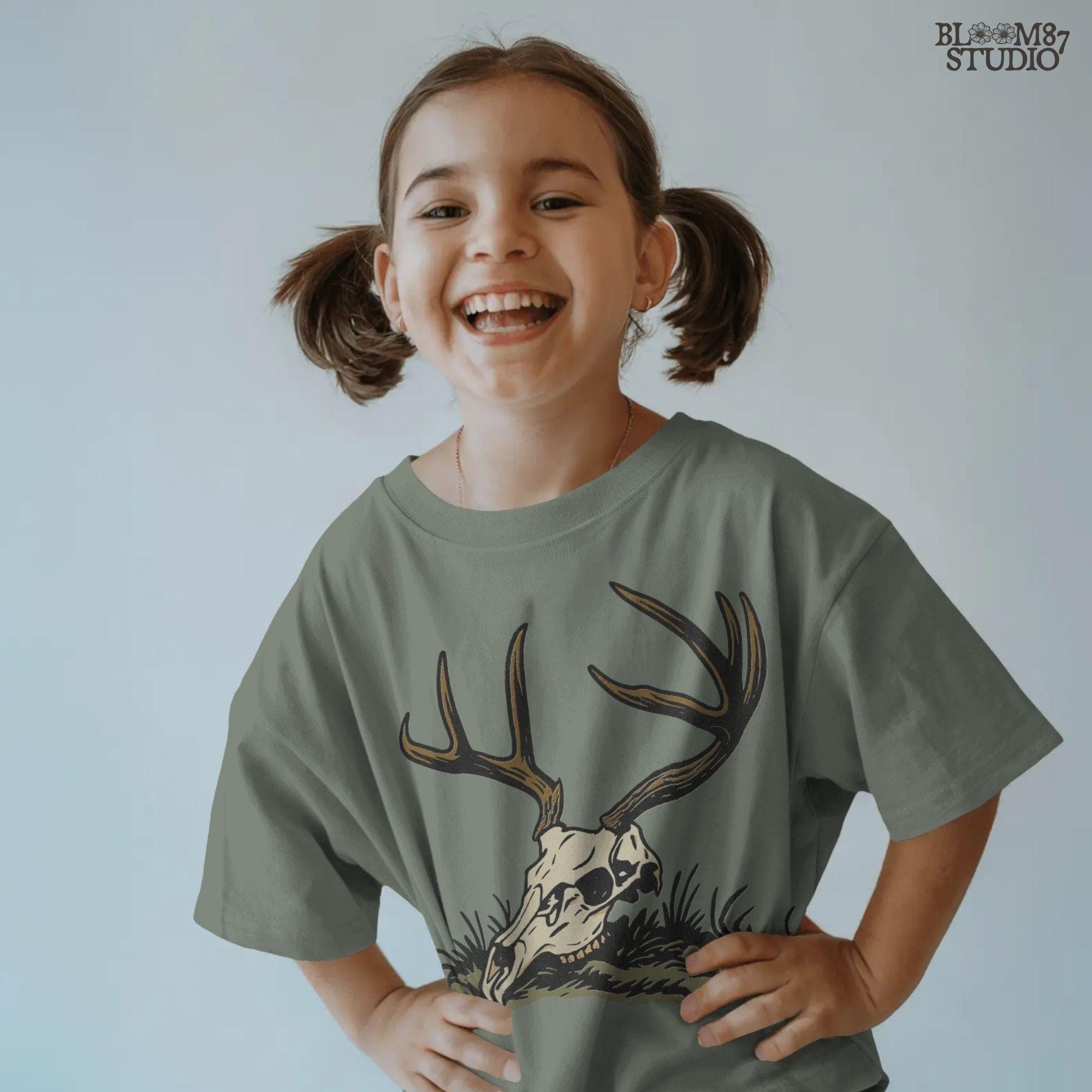 Rustic illustration of a deer skull with large antlers lying on grass, PNG design for hunting-themed and western-style sublimation crafts