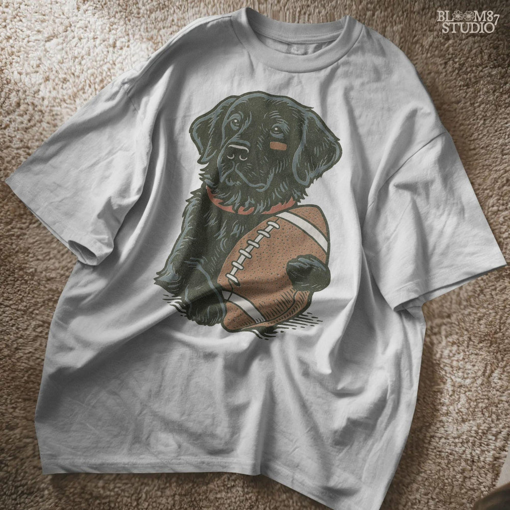 Illustration of a black Labrador Retriever holding a football, sublimation PNG design for game day and sports fan apparel.