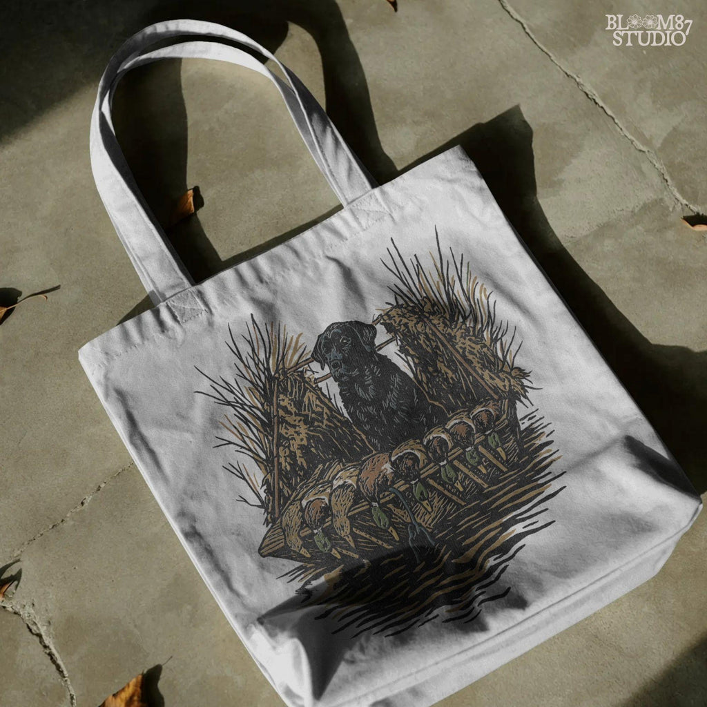 Black hunting retriever dog sitting in a duck blind with harvested mallards, rustic waterfowl hunting sublimation PNG design.