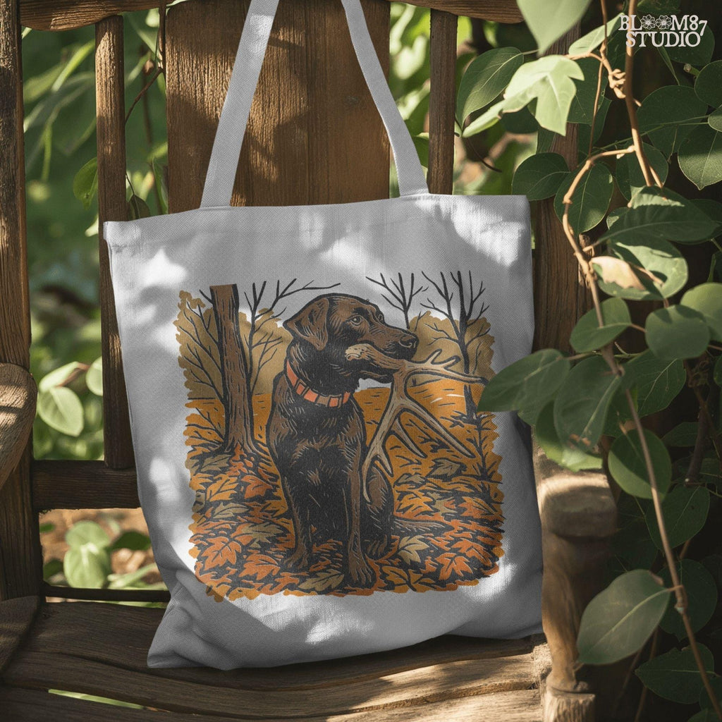 Illustration of a black Labrador dog sitting in autumn leaves holding a deer antler in its mouth, rustic hunting sublimation PNG design.