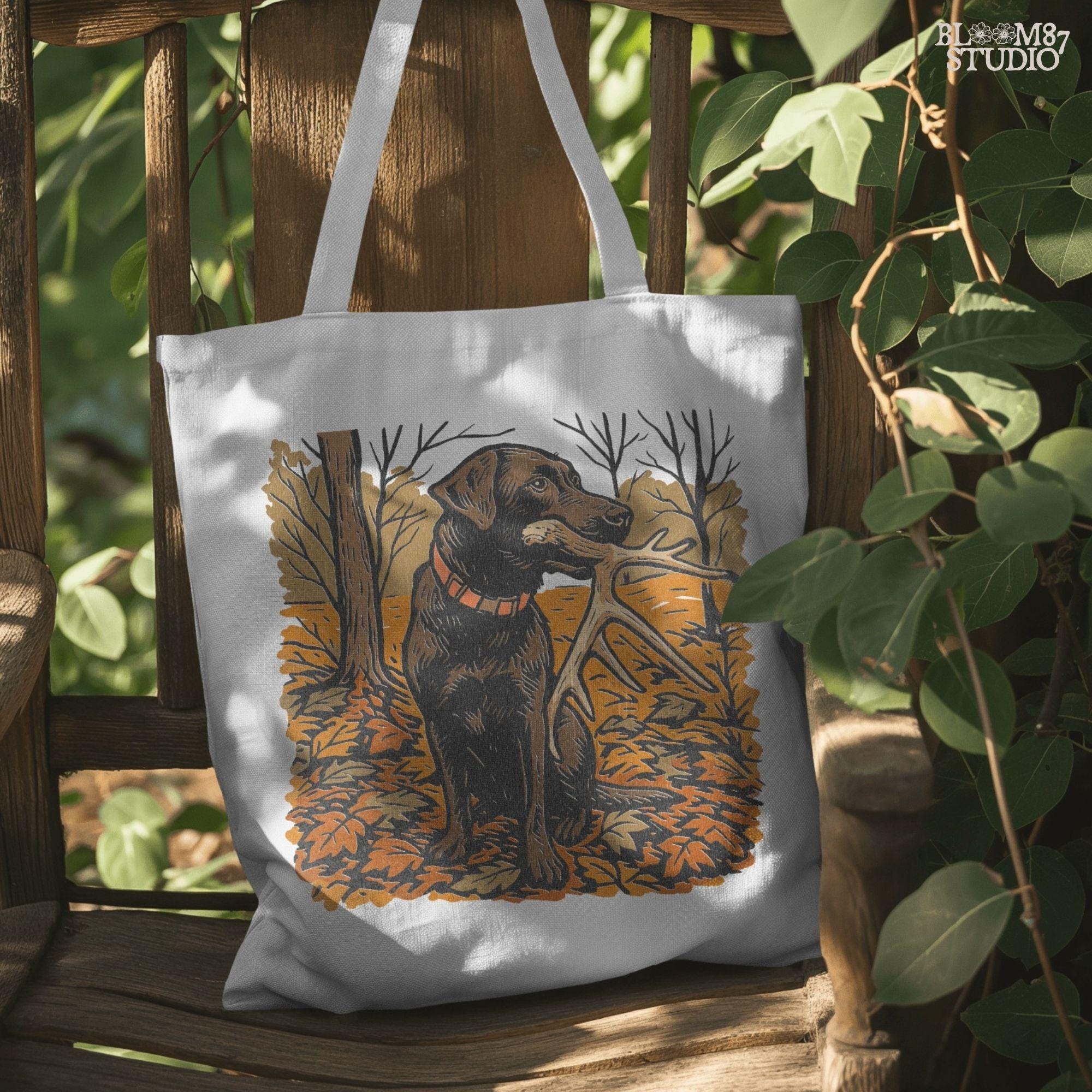 Illustration of a black Labrador dog sitting in autumn leaves holding a deer antler in its mouth, rustic hunting sublimation PNG design.