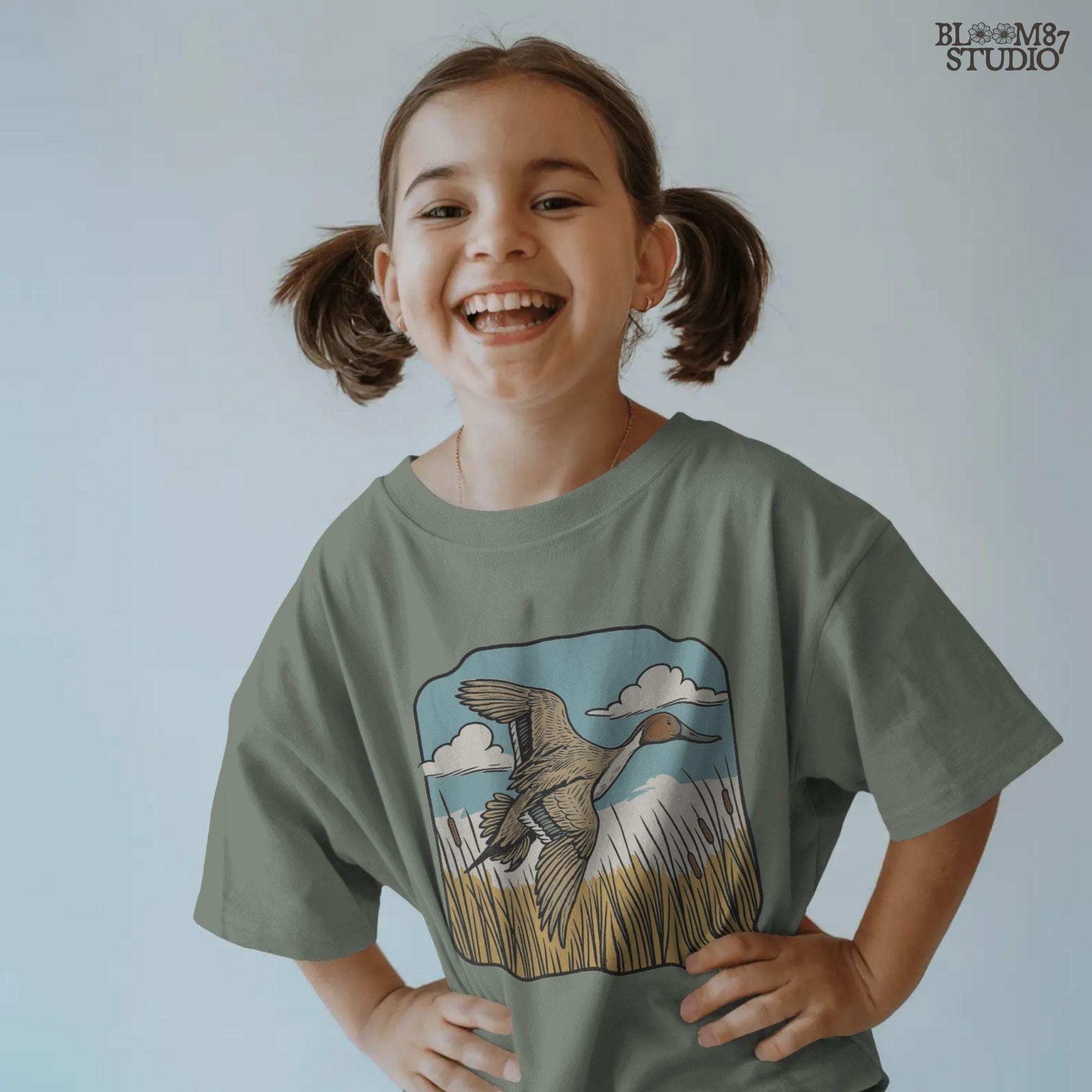 Illustration of a pintail duck flying above cattails with a blue sky and clouds, rustic waterfowl hunting sublimation PNG design.