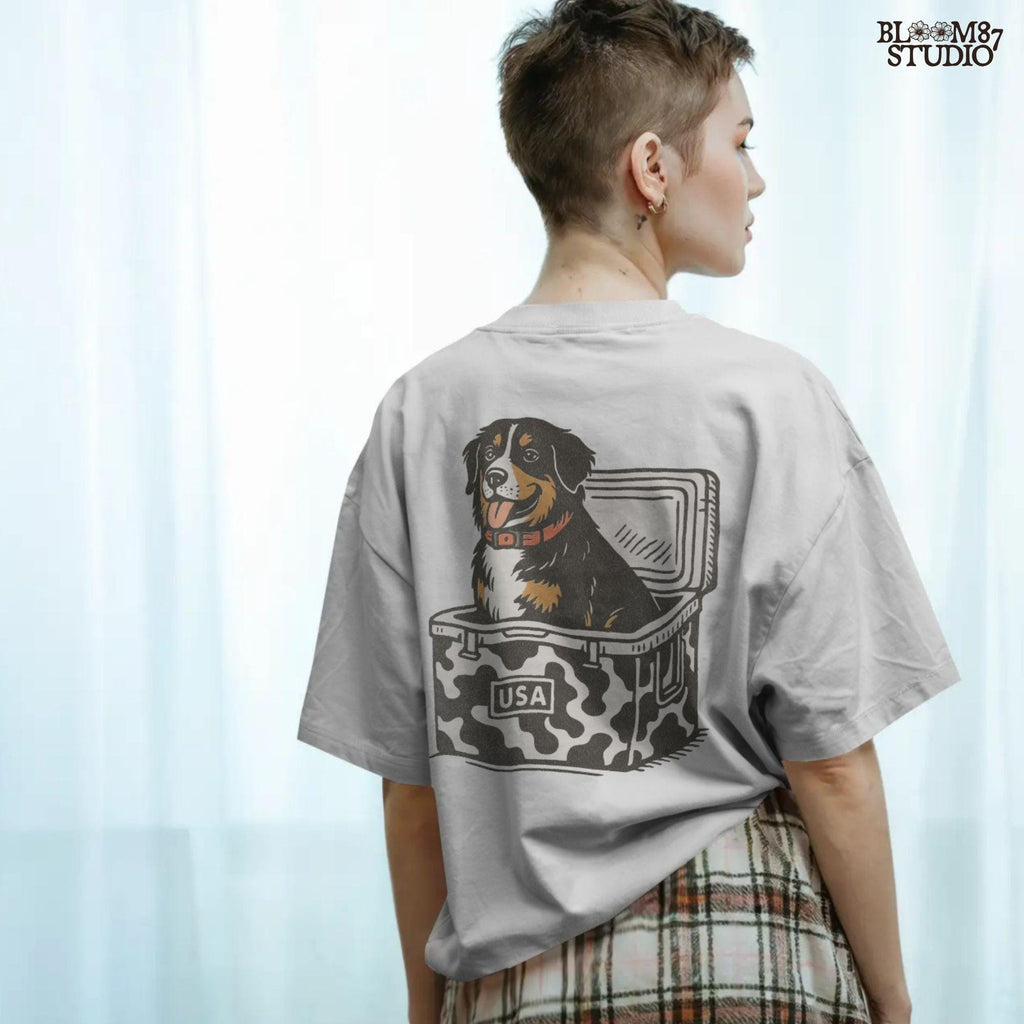 Bernese Mountain Dog sitting in a USA camo cooler, sublimation PNG design for hunting, camping, tailgate, and outdoor lifestyle projects.