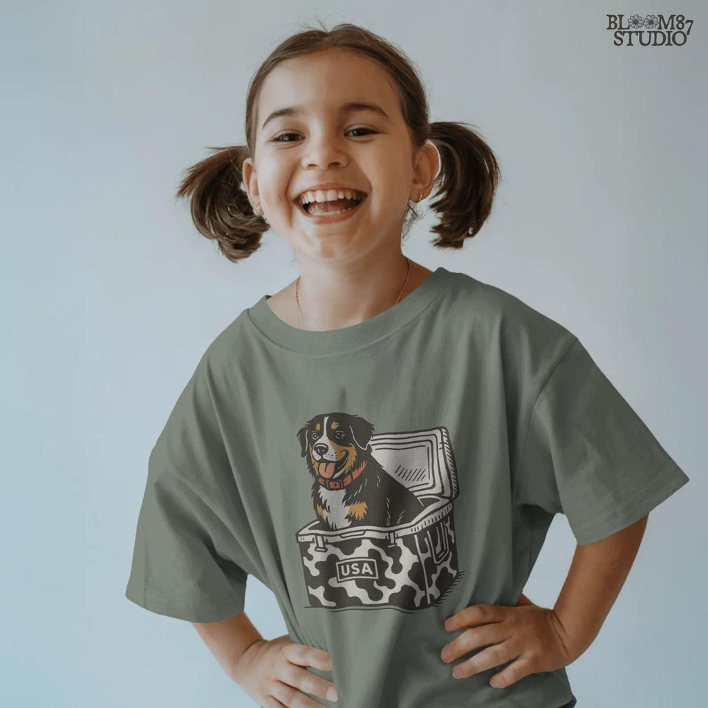 Bernese Mountain Dog sitting in a USA camo cooler, sublimation PNG design for hunting, camping, tailgate, and outdoor lifestyle projects.