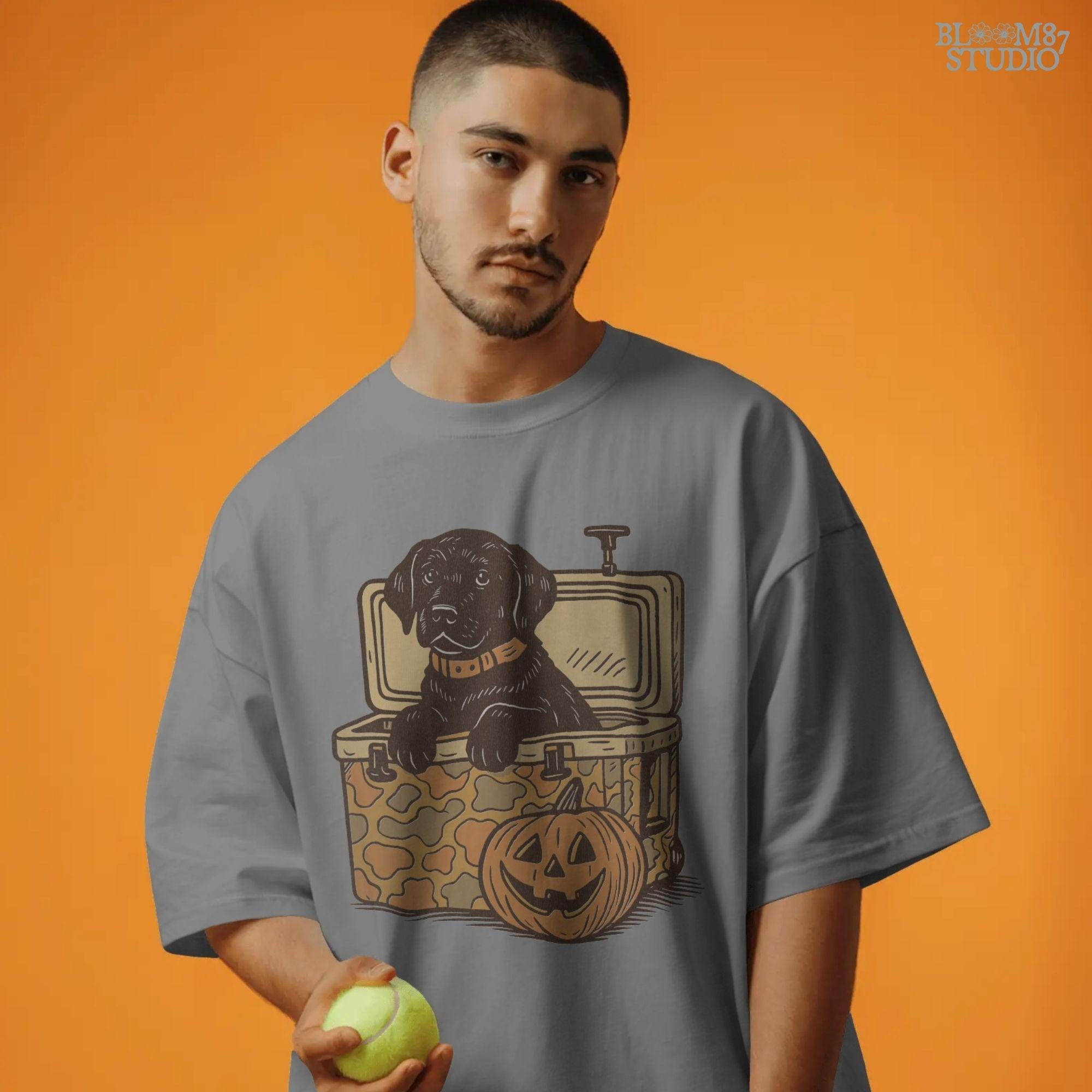 Black Labrador retriever sitting in a cooler with a pumpkin, Halloween sublimation PNG design for dog lovers, seasonal crafts, and apparel.