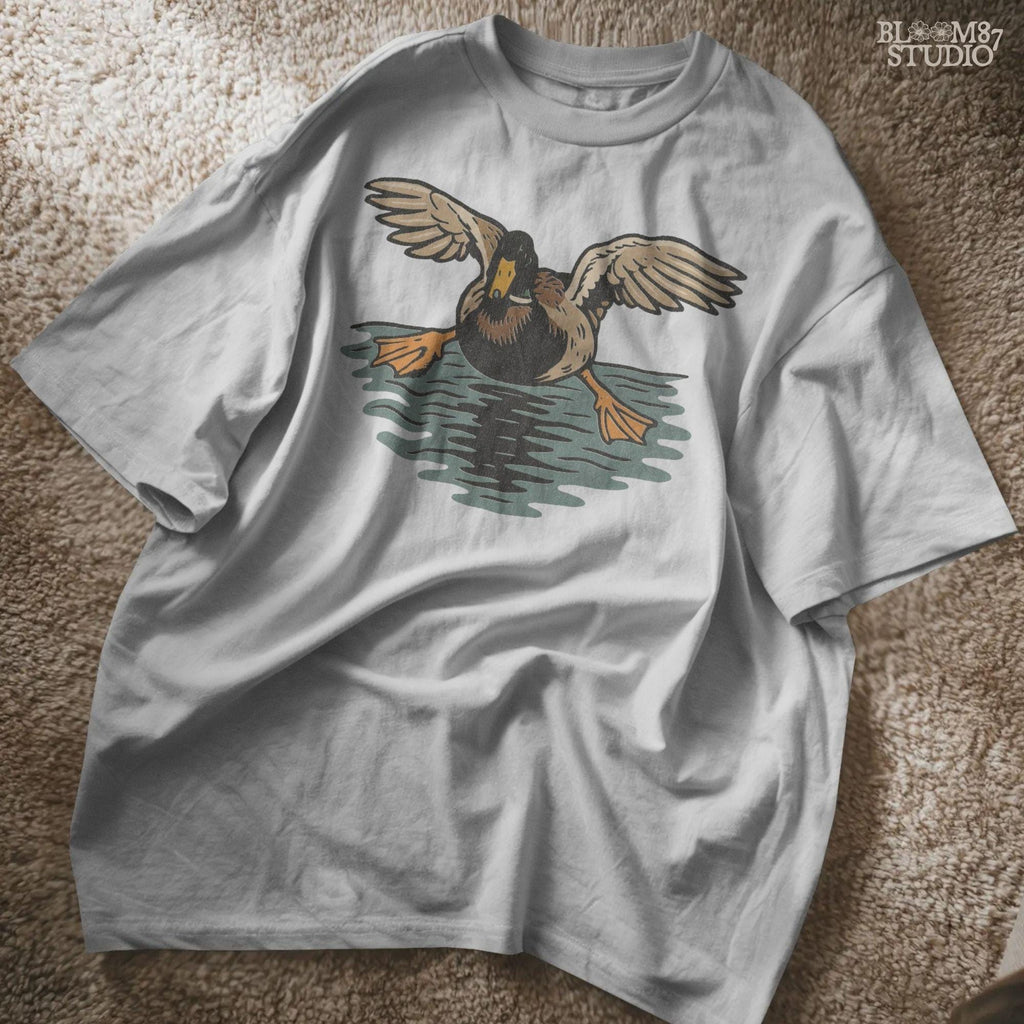 Solid Version:
Vintage-style sublimation of a duck landing on water with wings spread wide, great for rustic shirts or wildlife-themed crafts.

Distressed Version:
Distressed flying duck illustration landing on a pond, rustic clipart style ideal for outdoor nature designs and hunting-themed sublimation.