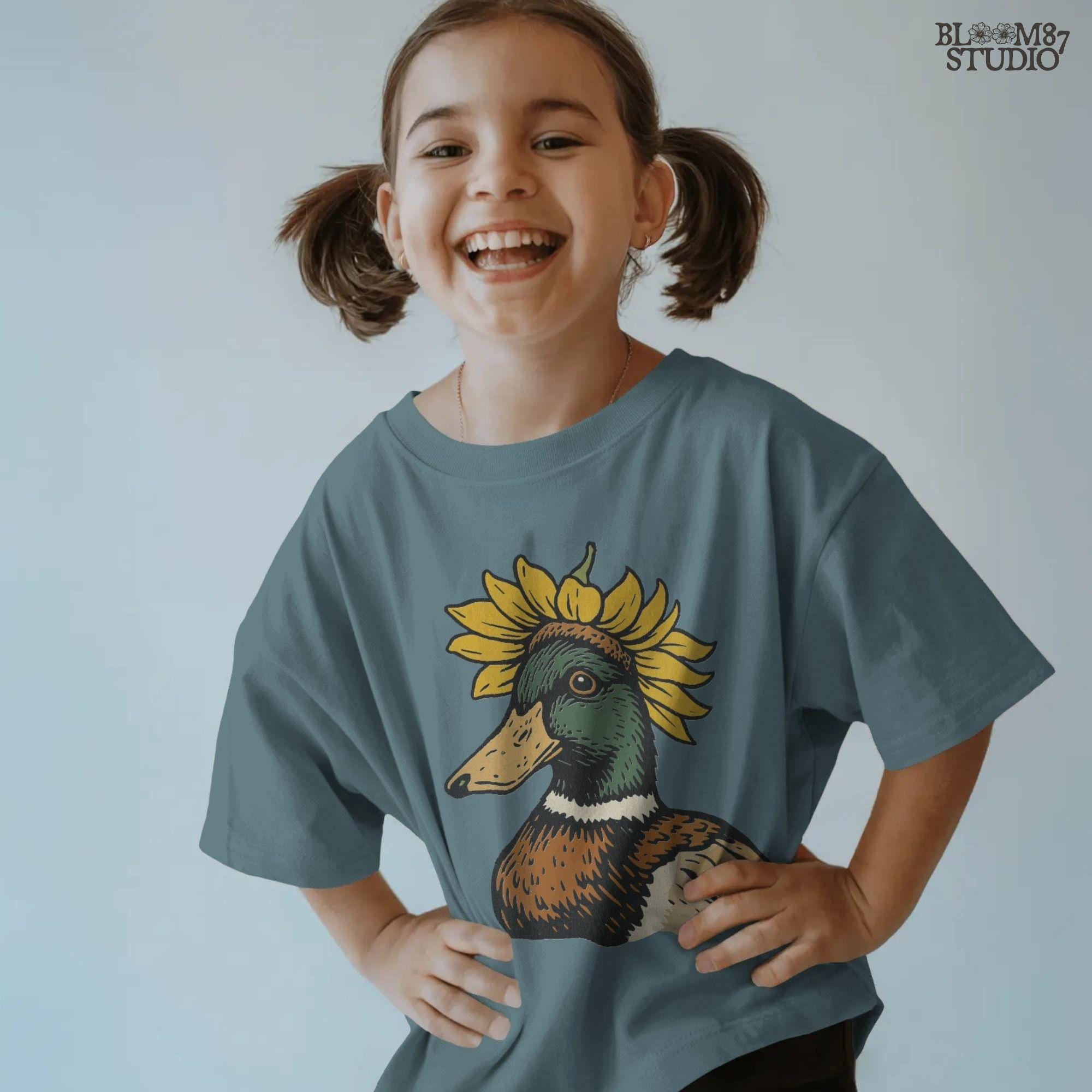 Solid Version:
Vintage illustration of a mallard duck head with a sunflower crown, sublimation PNG for farmhouse crafts and quirky animal designs.

Distressed Version:
Distressed-style sunflower duck head illustration, rustic sublimation PNG perfect for fall farmhouse art and whimsical wildlife projects.