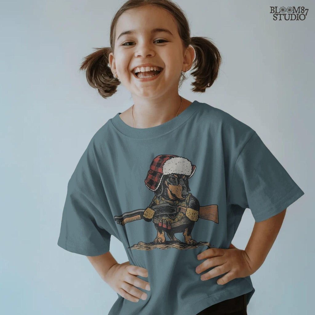 Solid Version:
Vintage illustration of a dachshund wearing a plaid trapper hat and holding a rifle, funny sublimation PNG for hunting-themed crafts and rustic lodge art.

Distressed Version:
Distressed artwork of a hunting dachshund in plaid hat with rifle, quirky sublimation PNG for rustic lodge decor, humorous shirts, and pet designs.