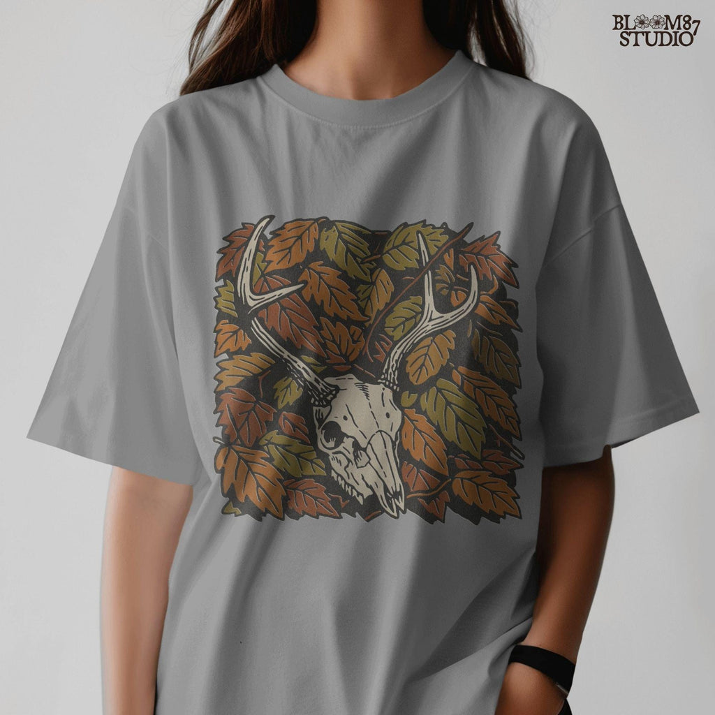 Deer skull with antlers surrounded by autumn leaves, rustic fall hunting sublimation PNG design.