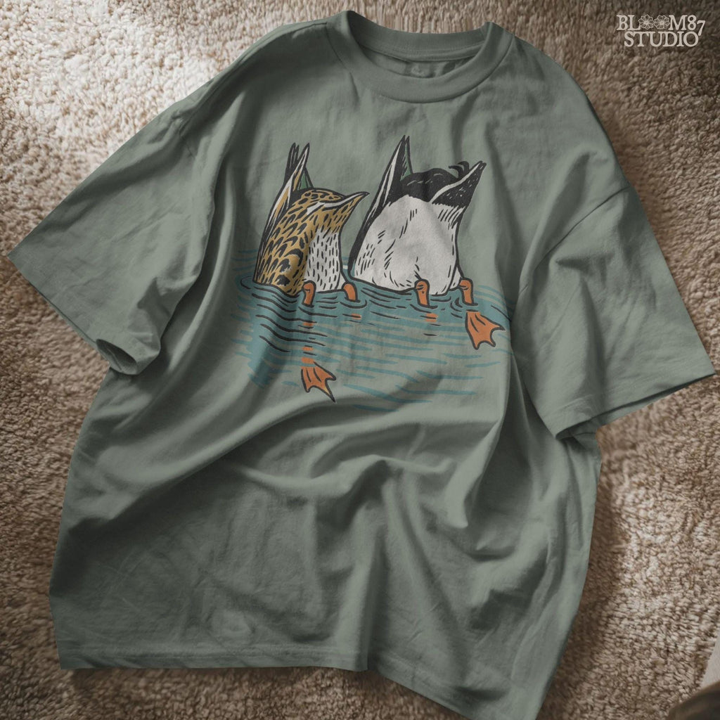 Solid version:
“Two ducks dabbling with tails up and feet in water – funny duck sublimation PNG for hunting shirts and rustic crafts”

Distressed version:
“Vintage distressed sublimation PNG of two ducks with tails up in pond – funny waterfowl hunting and rustic outdoor design”