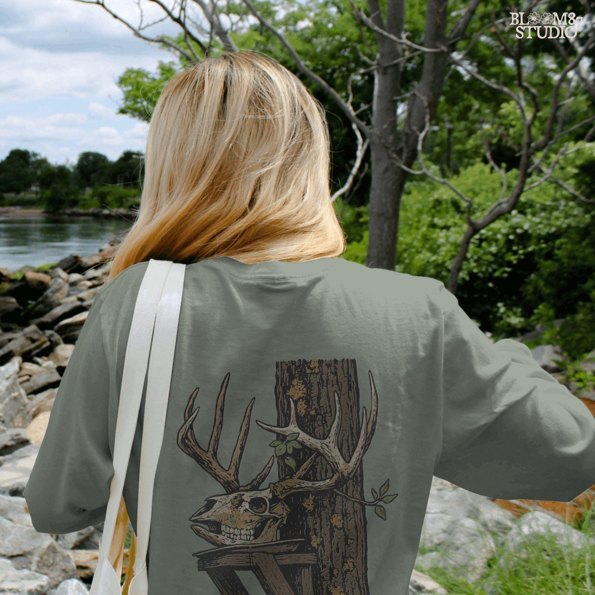 Solid version: Illustration of a deer skull with antlers leaning on a tree, spooky hunting Halloween PNG.
Distressed version: Vintage distressed deer skull with antlers and rustic tree background, hunting lodge Halloween PNG.