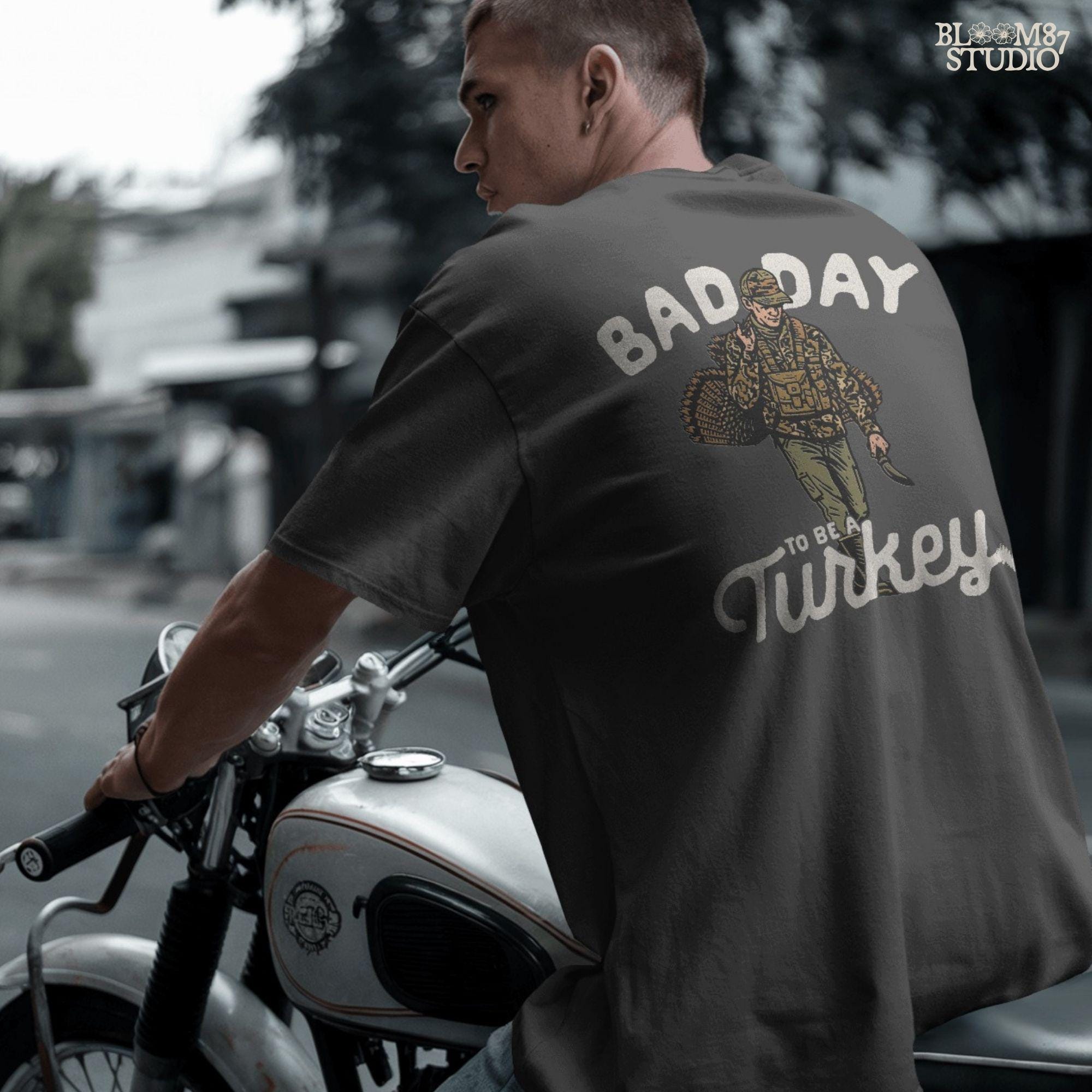 Camouflage-clad hunter carrying a wild turkey, paired with bold text “Bad Day To Be A Turkey.” This turkey hunting design is suitable for Thanksgiving gift shirts, hunting mugs, and custom tumbler wraps.