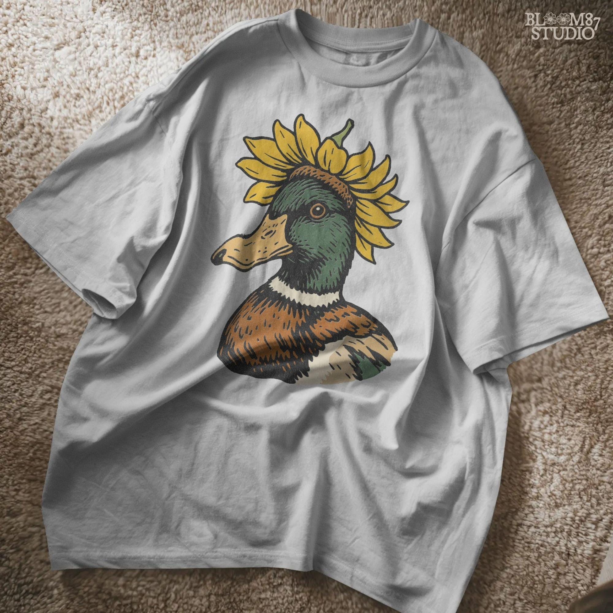 Solid Version:
Vintage illustration of a mallard duck head with a sunflower crown, sublimation PNG for farmhouse crafts and quirky animal designs.

Distressed Version:
Distressed-style sunflower duck head illustration, rustic sublimation PNG perfect for fall farmhouse art and whimsical wildlife projects.
