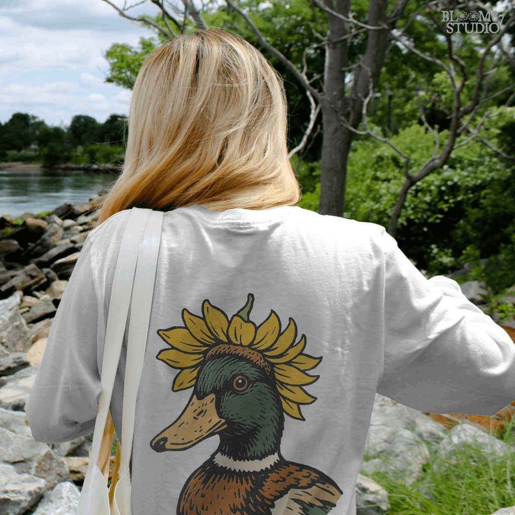 Solid Version:
Vintage illustration of a mallard duck head with a sunflower crown, sublimation PNG for farmhouse crafts and quirky animal designs.

Distressed Version:
Distressed-style sunflower duck head illustration, rustic sublimation PNG perfect for fall farmhouse art and whimsical wildlife projects.