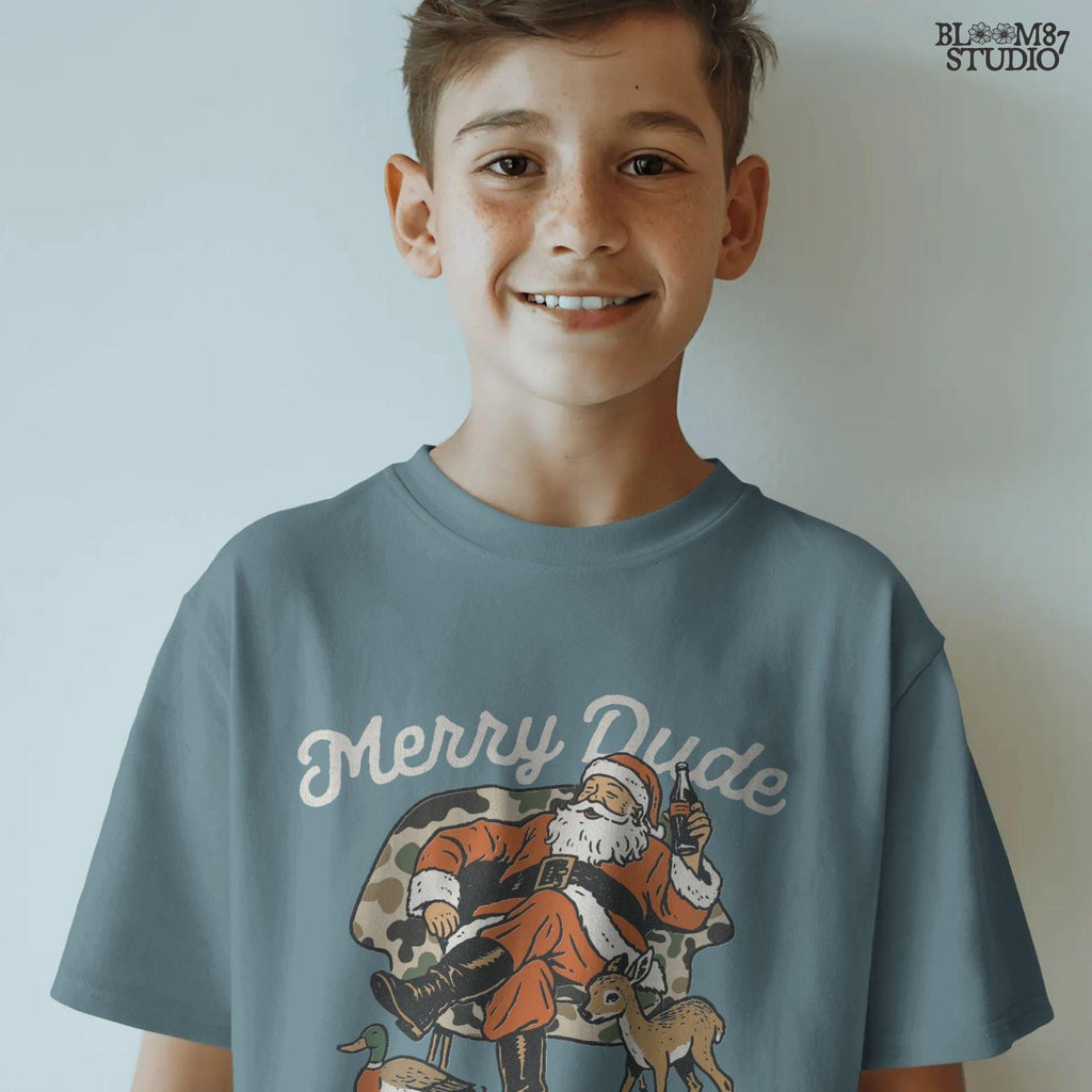Festive Santa Claus artwork with camo accents, Merry Dude lettering, deer fawn, and duck, relaxed holiday pose. Designed for Christmas camo shirt design, Santa sublimation projects, Christmas decor, and holiday gifts.