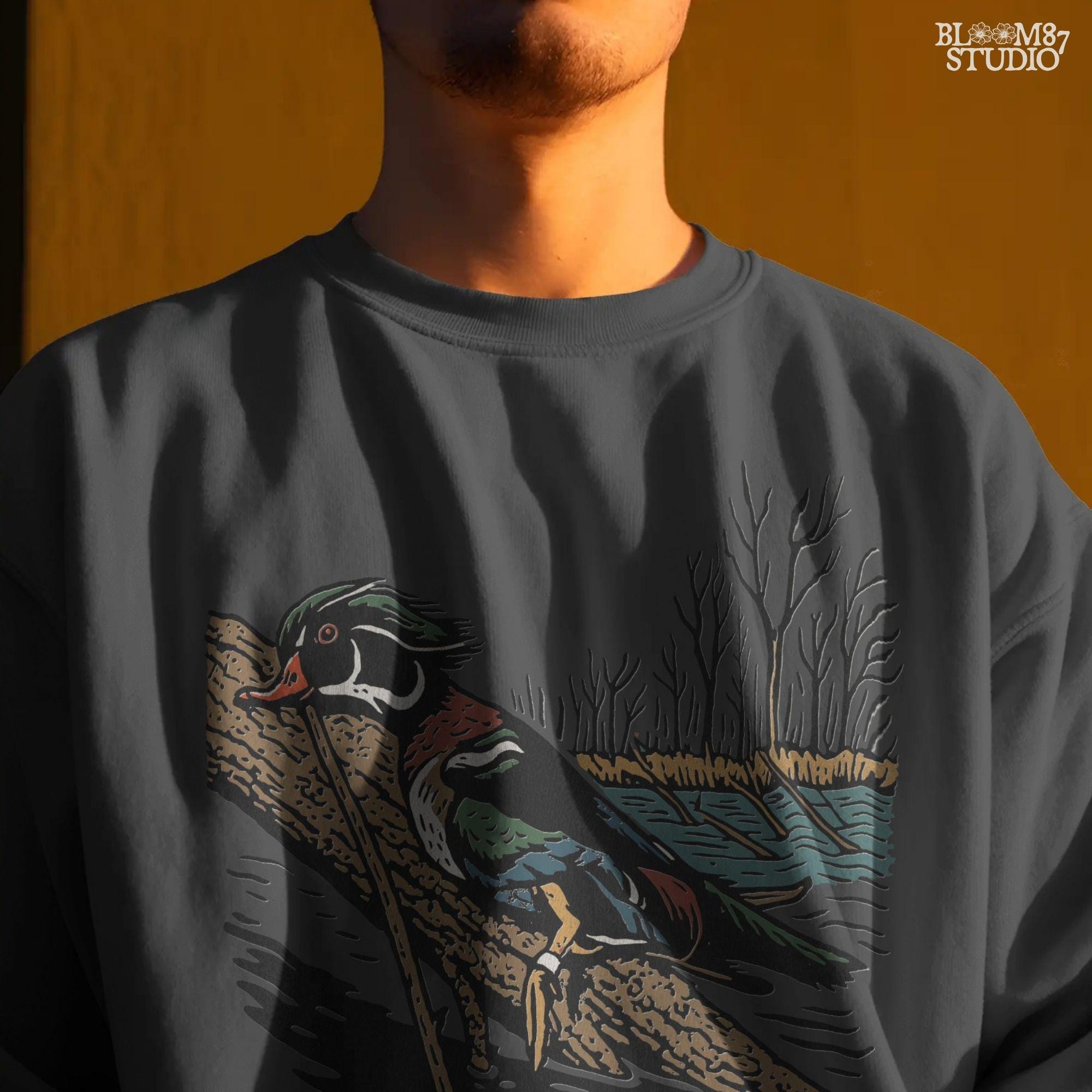 Solid version:
“Colorful wood duck perched on tree branch by lake with trees – waterfowl sublimation PNG for hunting and outdoor crafts”

Distressed version:
“Vintage distressed sublimation PNG of wood duck on branch by lake and trees – rustic hunting and lodge décor design”