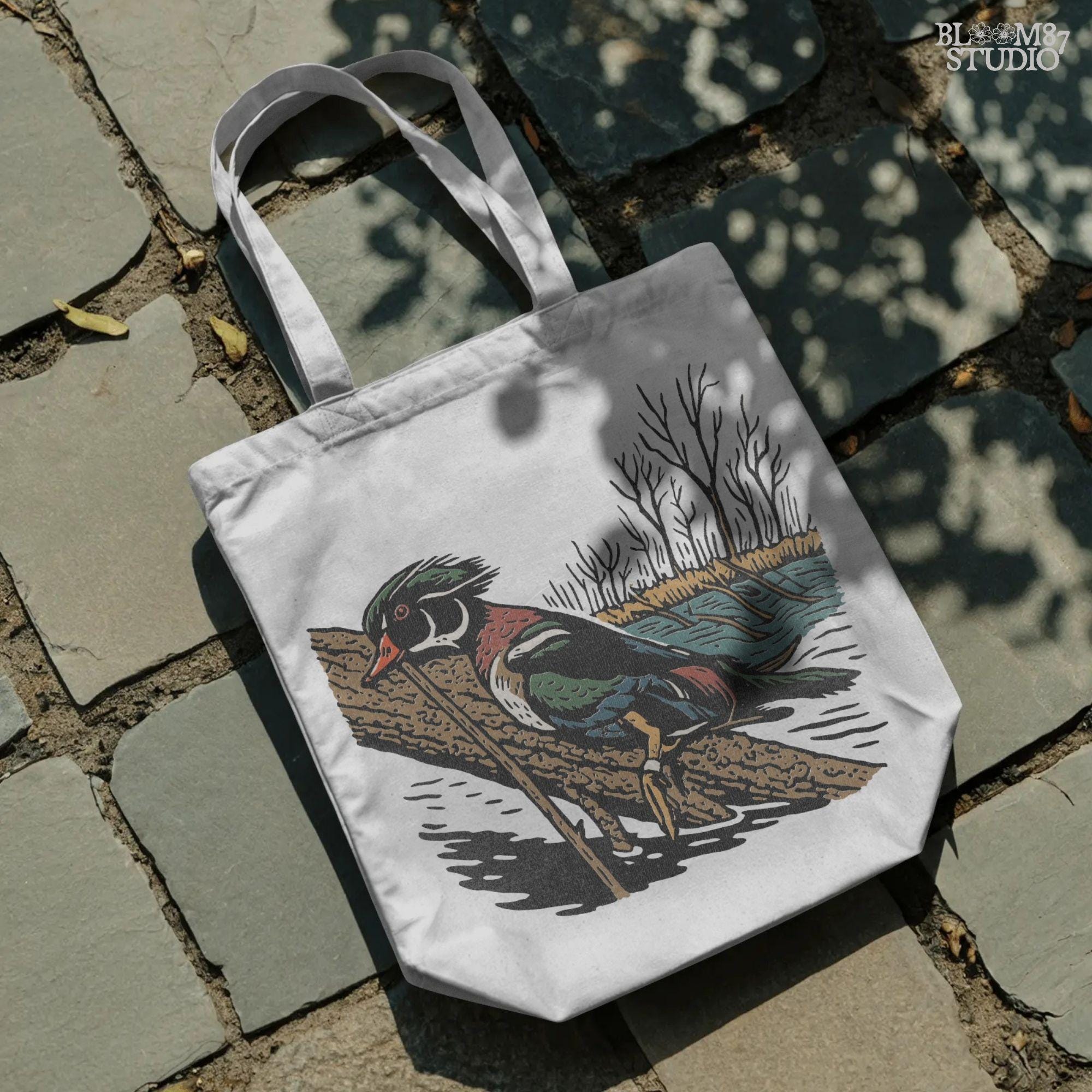 Solid version:
“Colorful wood duck perched on tree branch by lake with trees – waterfowl sublimation PNG for hunting and outdoor crafts”

Distressed version:
“Vintage distressed sublimation PNG of wood duck on branch by lake and trees – rustic hunting and lodge décor design”
