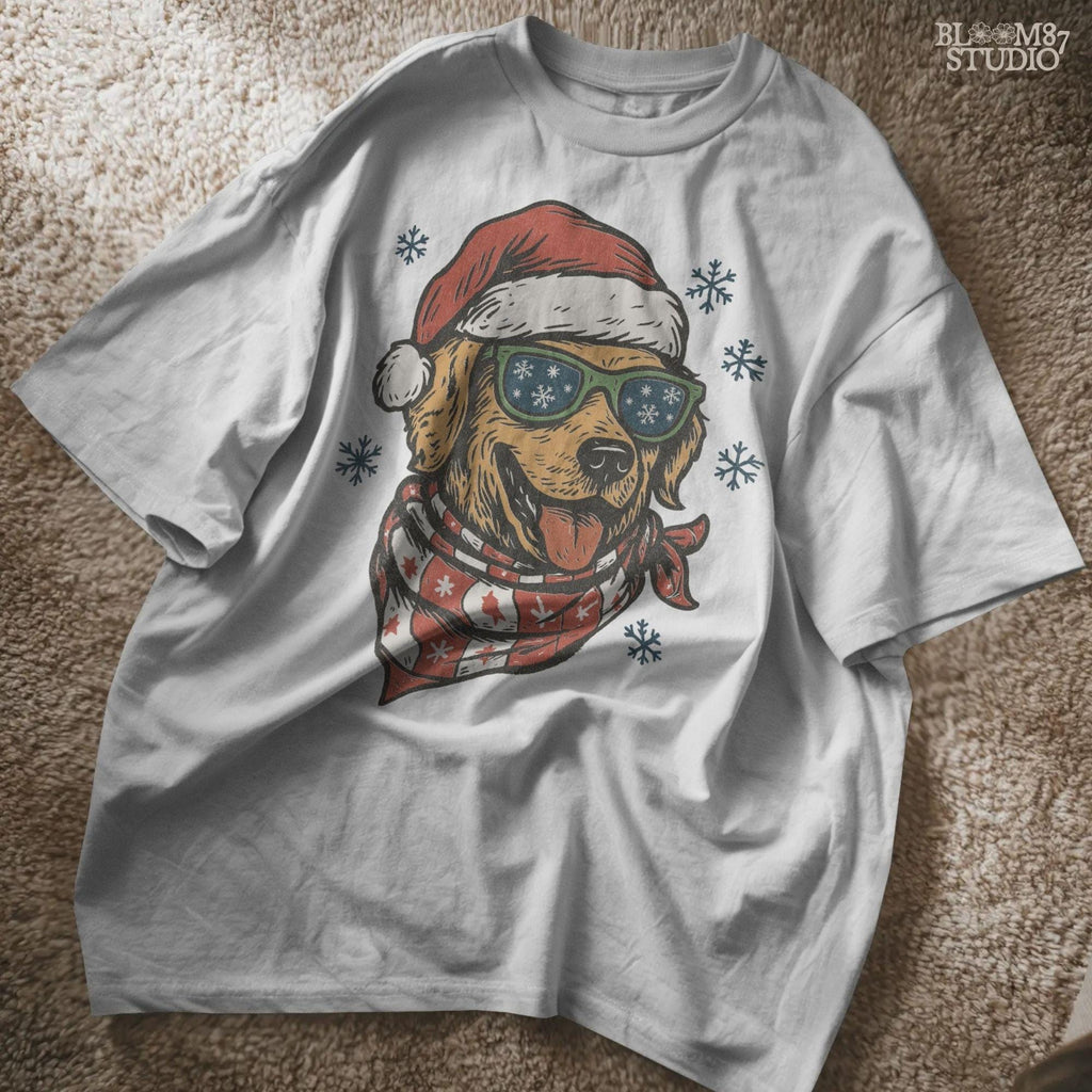 Cute Christmas dog PNG clipart showing retriever with festive scarf, Santa hat, and snowflakes around. Great for holiday sublimation shirts and seasonal gifts.