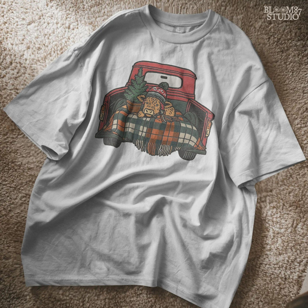 Holiday cow PNG clipart called Christmas Highland Cow. Features festive cow in winter beanie with plaid blanket inside red pickup truck. Great for sublimation projects like farmhouse Christmas shirts, mugs, holiday signs, and rustic decor gifts. High-quality transparent background.