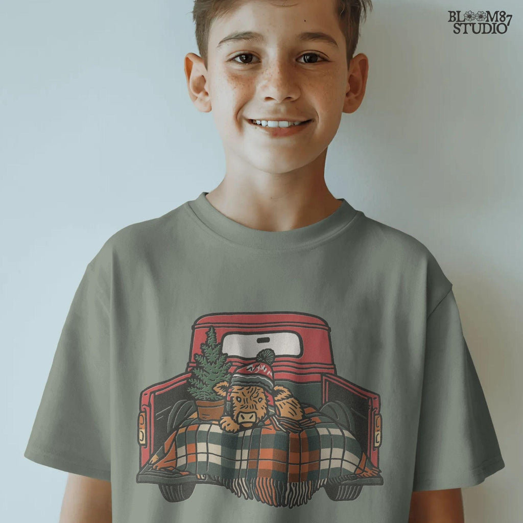 Christmas farmhouse PNG featuring Highland cow resting in red truck bed. Cow wears holiday beanie, plaid blanket, and sits with potted pine tree. Great sublimation artwork for rustic Christmas shirts, mugs, seasonal crafts, or farmhouse decor gifts.