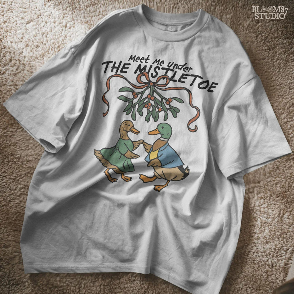 Festive duck pair in colorful winter clothing, placed under mistletoe with red berries, perfect for Christmas card design.