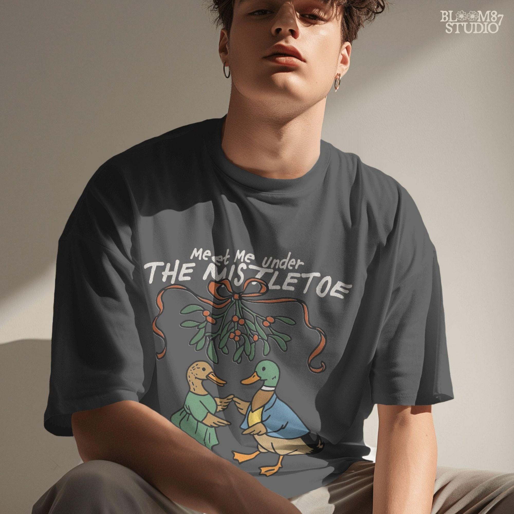 High-resolution duck couple in Christmas clothes, looking at each other under mistletoe with blue bow, great for printables.